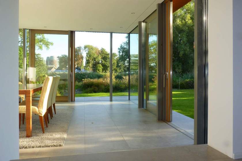 transparant-zicht-op-tuin-vanuit-moderne-uitbouw-glas-stuc-en-grote-vloertegels.jpg